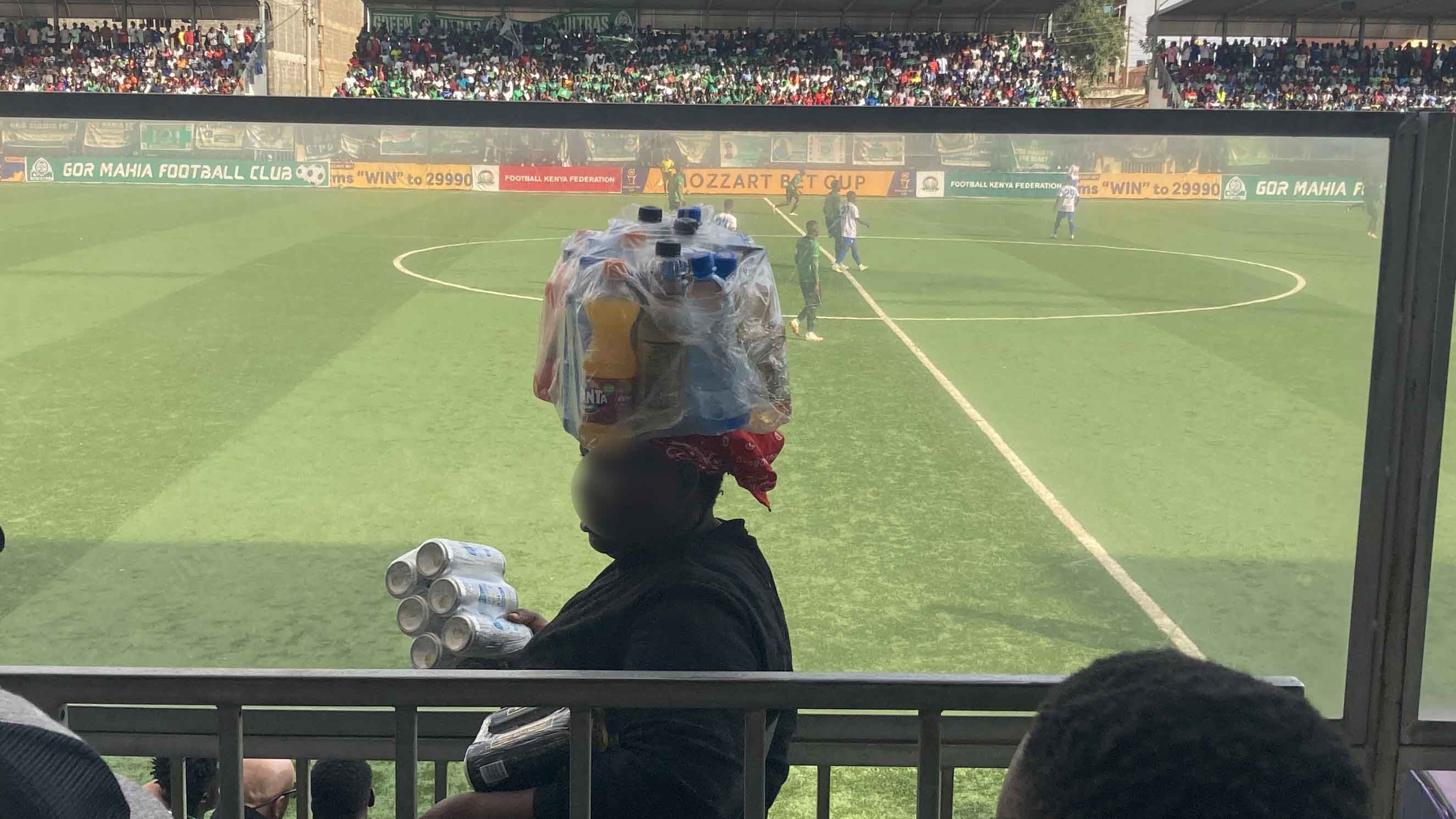 試合中に飲み物を頭に載せて販売する売り子。