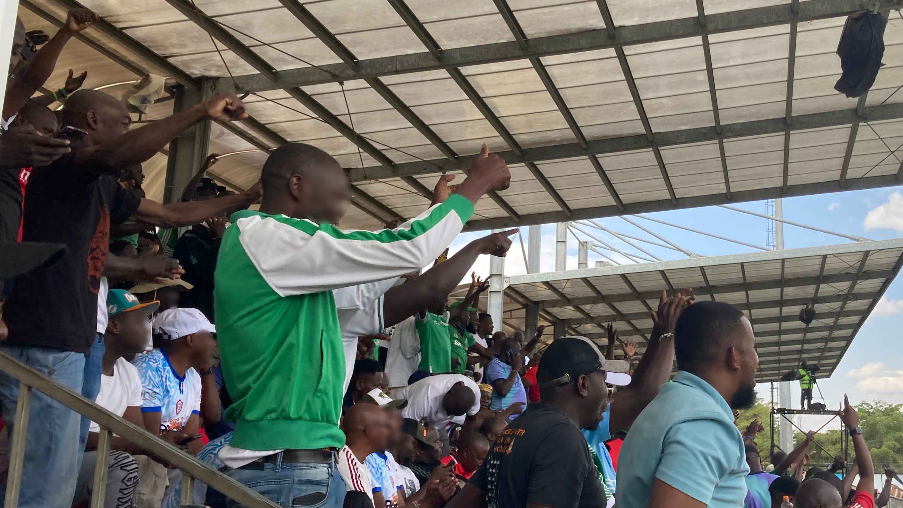 試合中にスタンドから声援を送る熱狂的なファンたち。