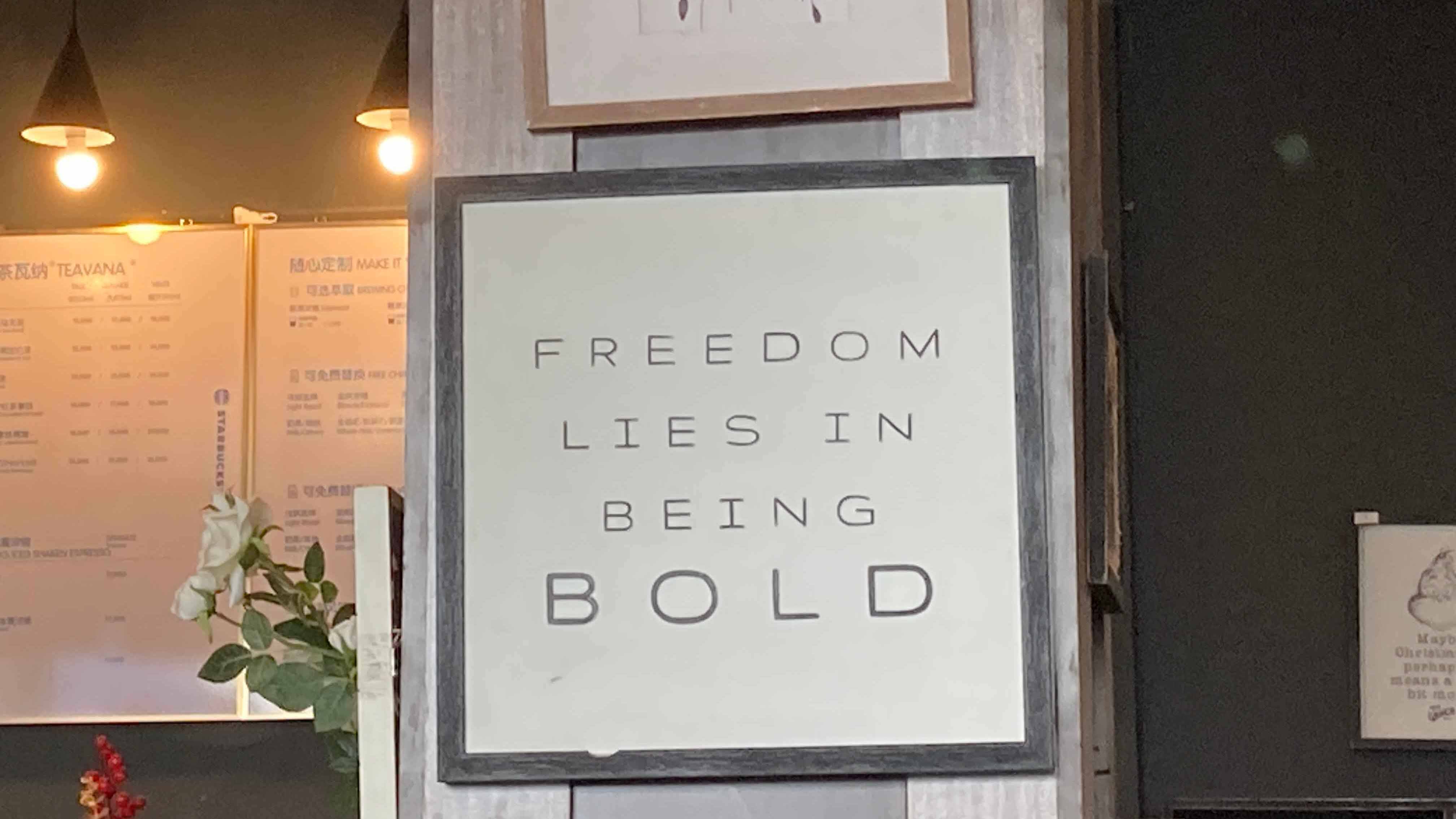 柱に飾られた「FREEDOM LIES IN BEING BOLD（自由は大胆さにある）」という引用文のアート。