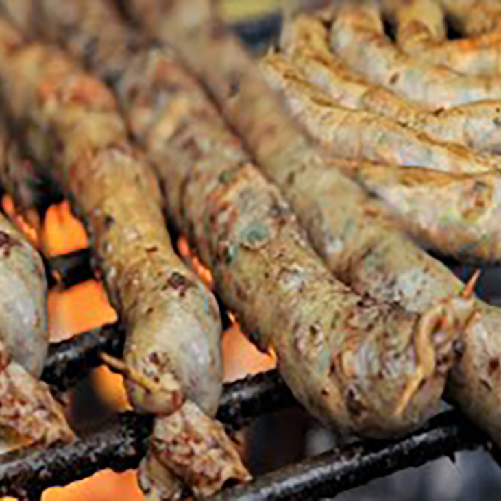 金網の上で炎に炙られながら焼かれるムトゥラソーセージ。