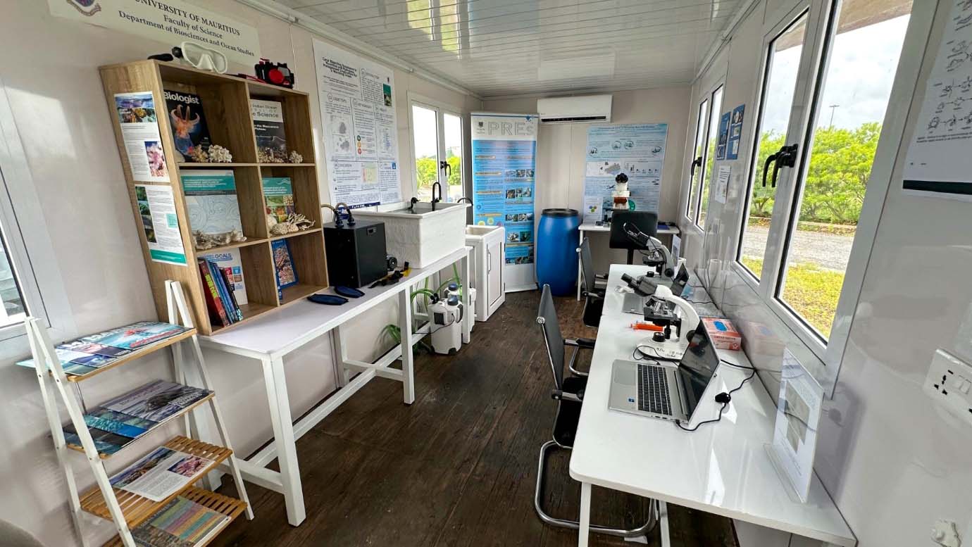 Interior of the marine station laboratory, showing workstations, microscopes, research materials, and educational displays for coral research.