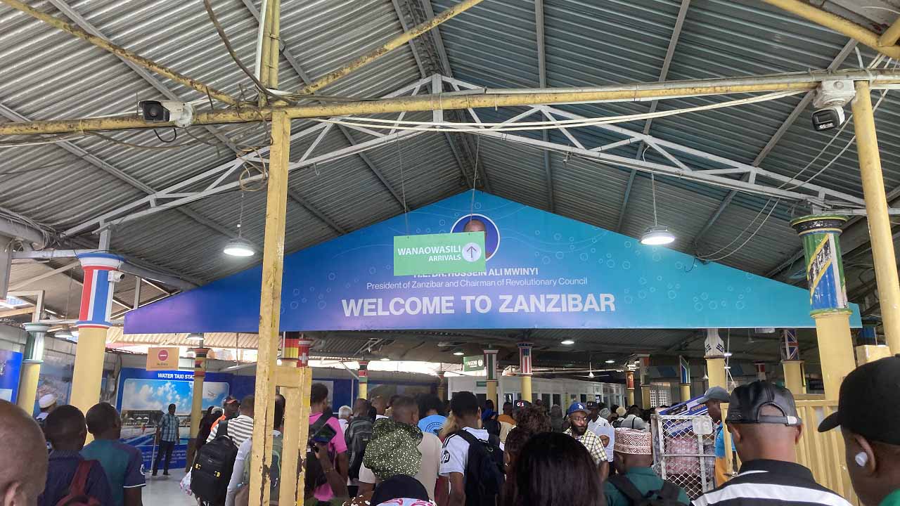 「Welcome to Zanzibar」の看板の下で、多くの到着客が集まるザンジバル港の到着エリア。
