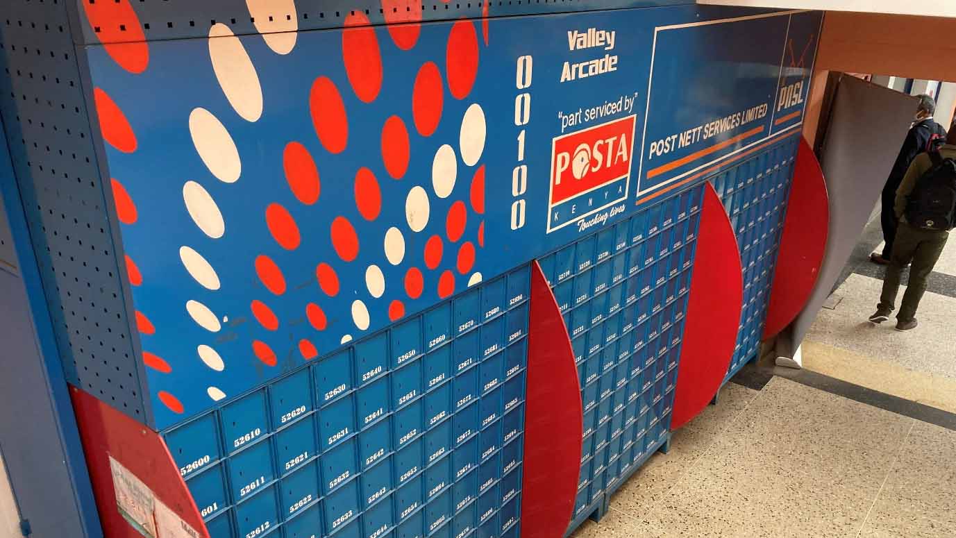 住宅地でバイク便による配送を行う配達員の様子。携帯電話での連絡や柔軟なルート対応が必要なケニアのラストワンマイル配送を表している。