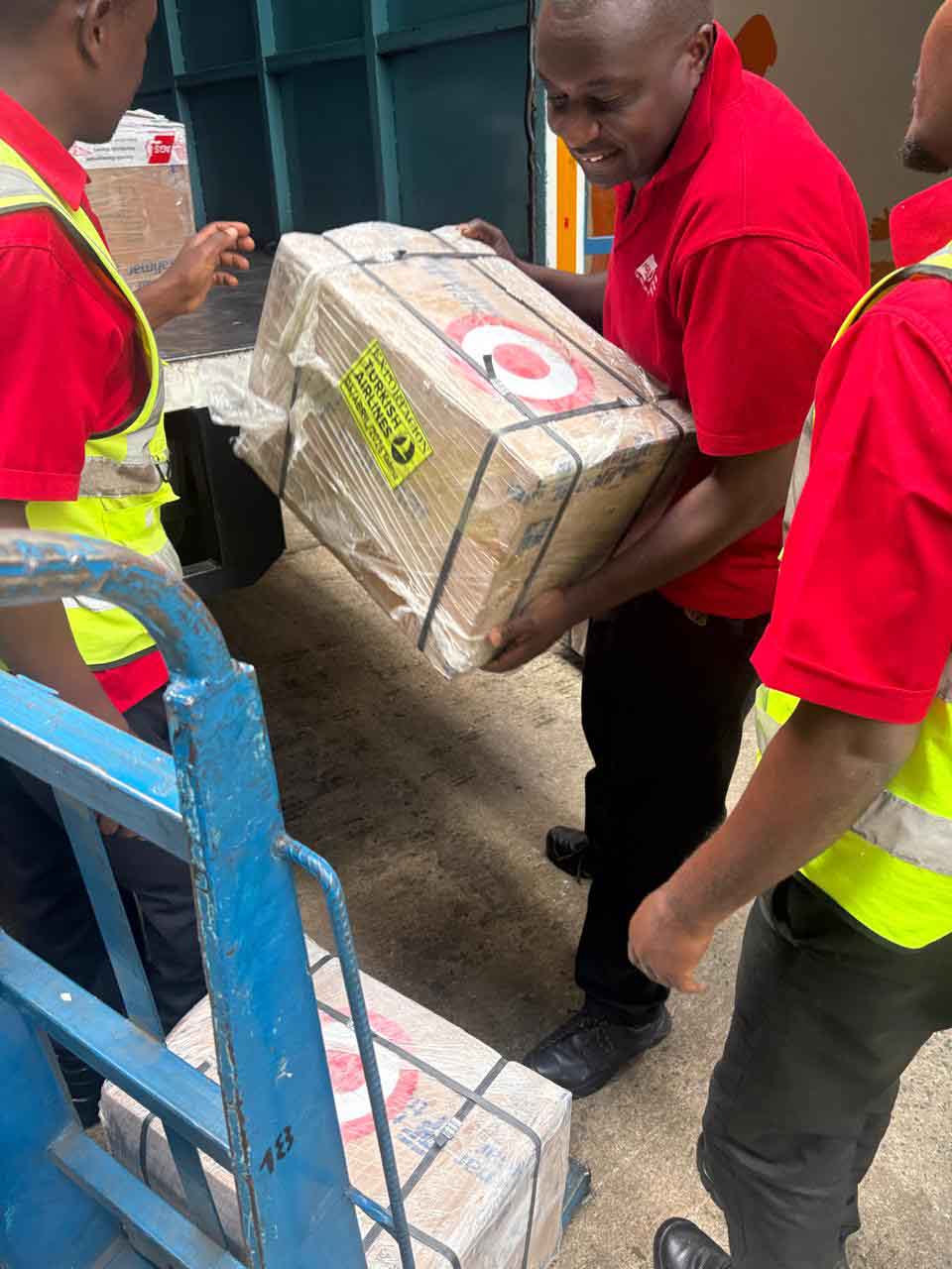 MOL Logistics staff unloading packed overseas shipment boxes from a truck during delivery operations in Kenya.
