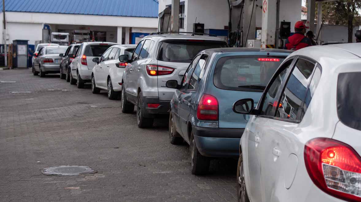 Long line of vehicles waiting at a petrol station, representing fuel supply concerns and the risk of shortages during periods of global energy instability.