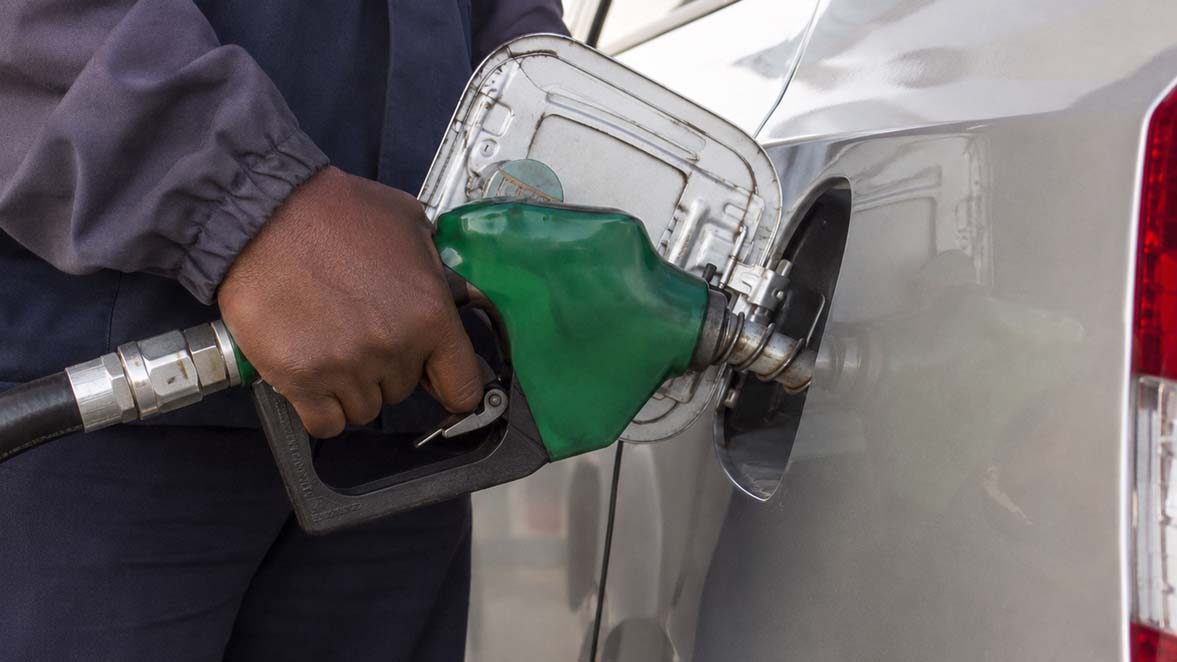 Close-up of a person refueling a vehicle at a petrol station, illustrating rising fuel costs and their impact on transportation and logistics in Southern Africa.