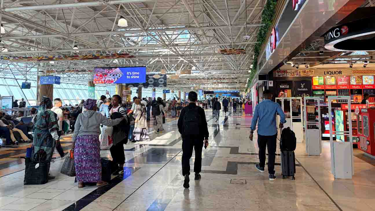 Passengers walking through the terminal at Addis Ababa Bole International Airport, a major hub for Ethiopian Airlines.
