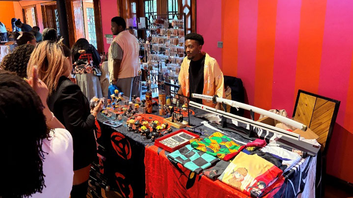 Vendor table displaying anime merchandise, character goods, and cosplay items at a Japanese culture festival in Kenya.