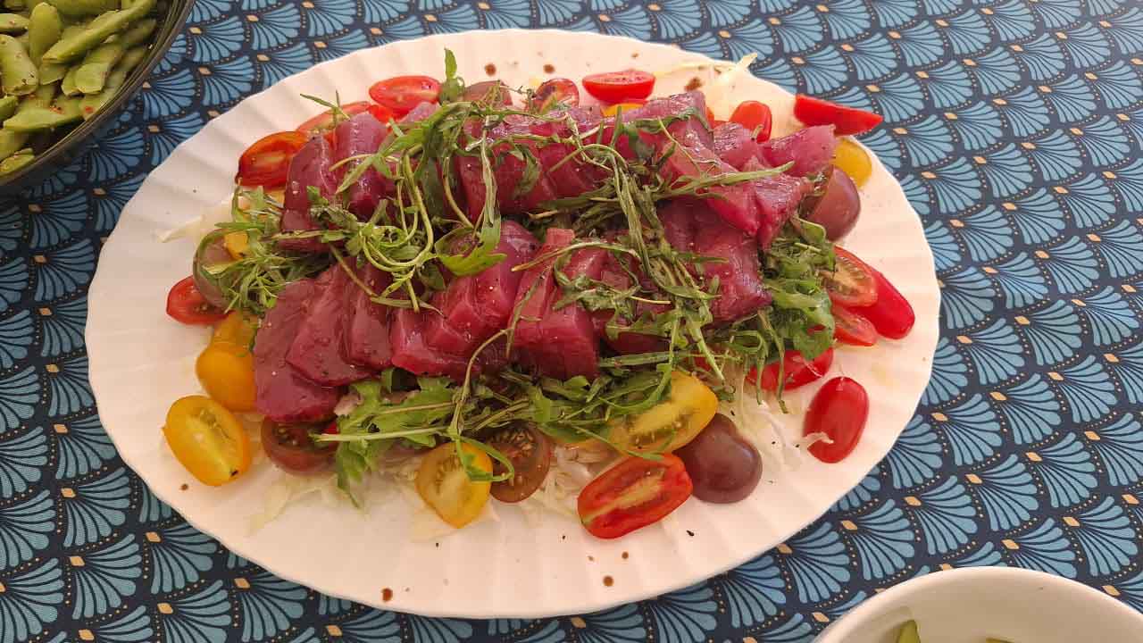 Fresh local fish served with herbs and colourful tomatoes as part of a Japanese-inspired culinary experience in Mauritius.